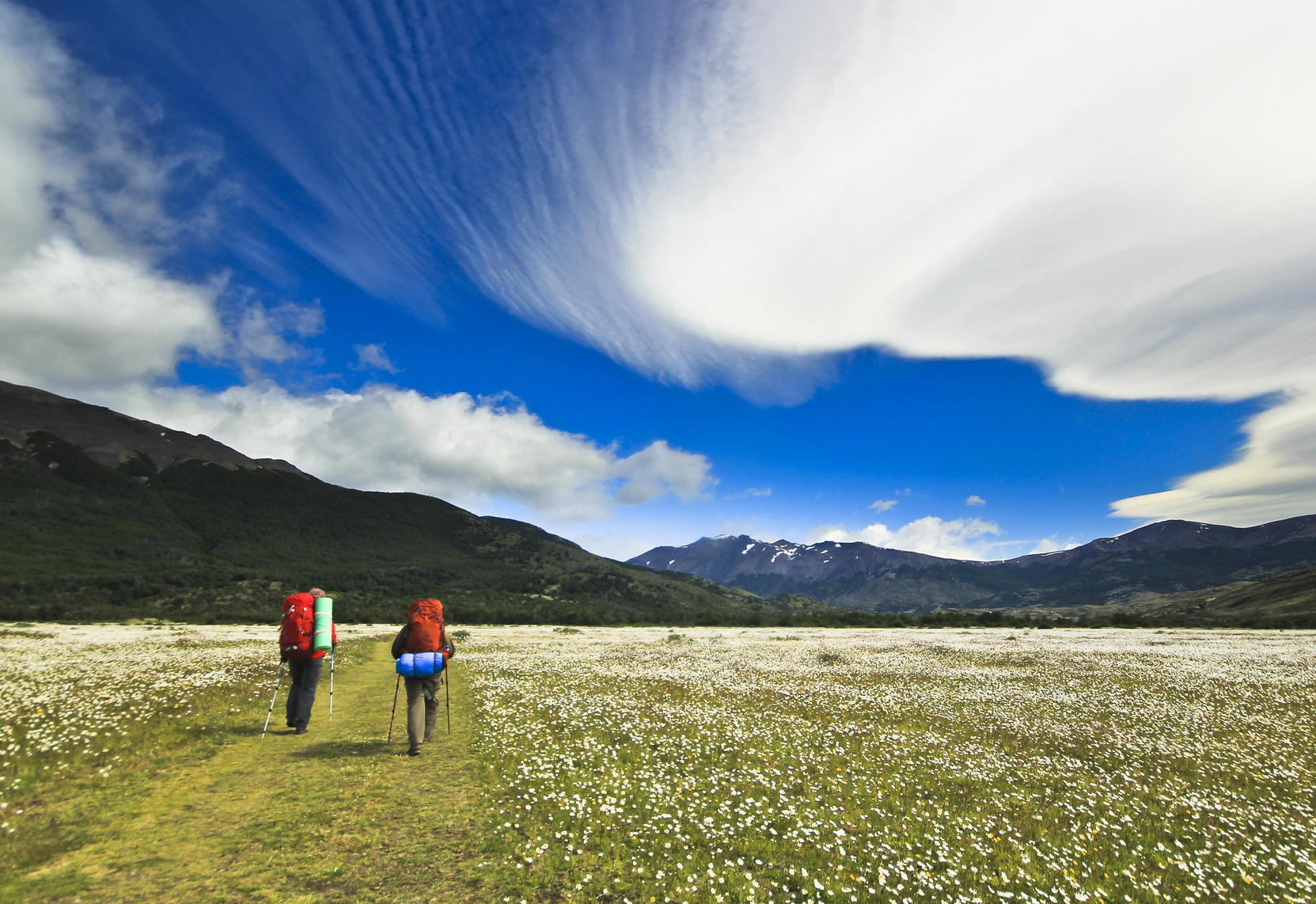 hikers going in patagonia mountains with beautiful clouds